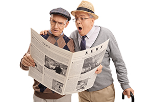 Two senior men reading newspaper