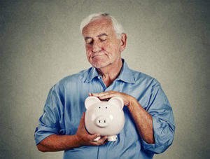 Senior man holding piggy bank